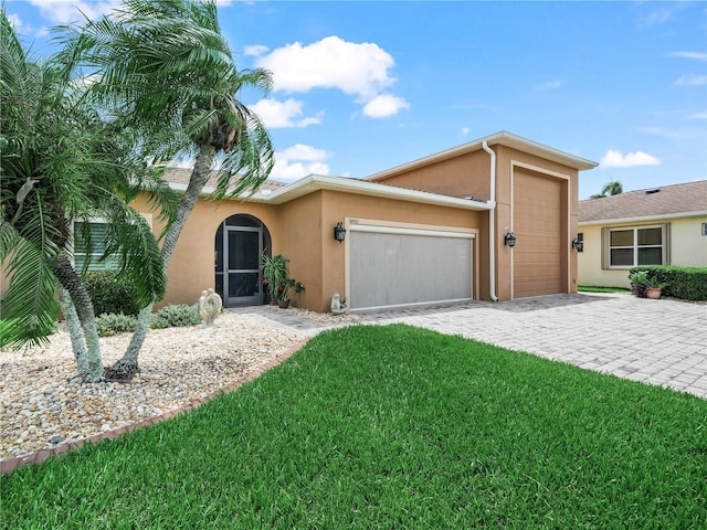 3802 Litchfield Loop, Lake Wales, FL 33859 - view of front facade featuring stucco siding, a garage, decorative driveway, and a front yard