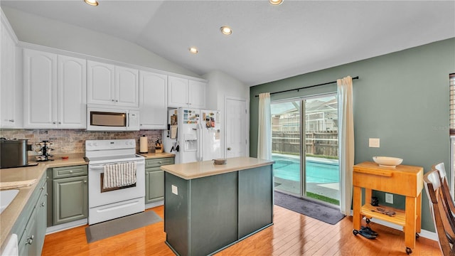 2602 Whitewood Rd, Mulberry, FL 33860 - kitchen with white appliances, vaulted ceiling, green cabinets, white cabinets, and a center island