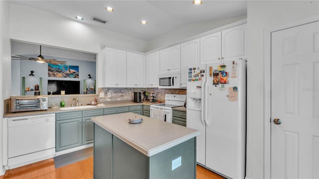 2602 Whitewood Rd, Mulberry, FL 33860 - kitchen with white appliances, decorative backsplash, light countertops, a kitchen island, and white cabinetry