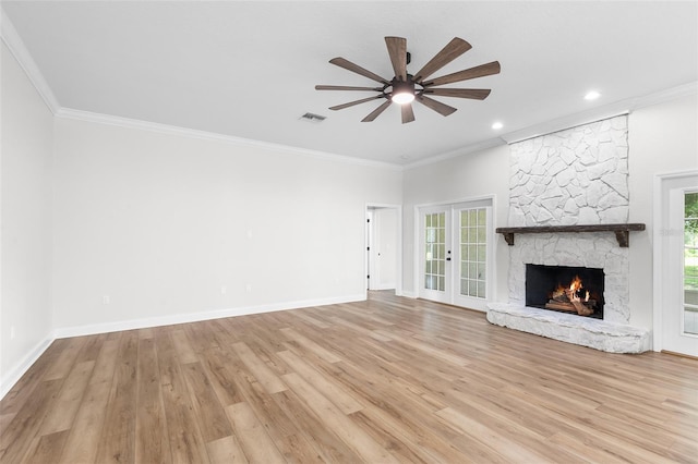 5820 E Johnson Ave, Haines City, FL 33844 - unfurnished living room featuring a ceiling fan, ornamental molding, light wood-style floors, a fireplace, and french doors