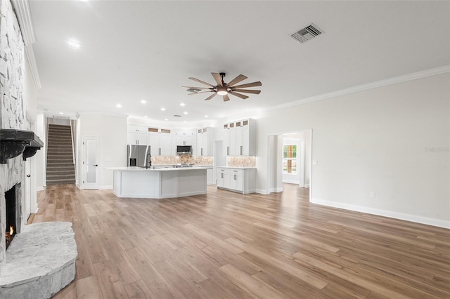 5820 E Johnson Ave, Haines City, FL 33844 - unfurnished living room with a large fireplace, ornamental molding, a ceiling fan, light wood-style flooring, and recessed lighting