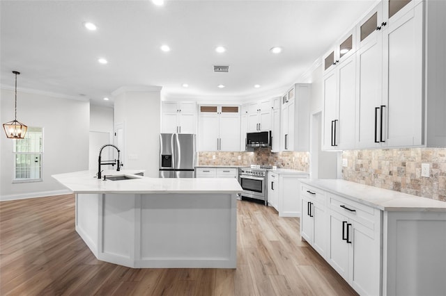 5820 E Johnson Ave, Haines City, FL 33844 - kitchen with stainless steel appliances, ornamental molding, a center island with sink, light wood-type flooring, and recessed lighting