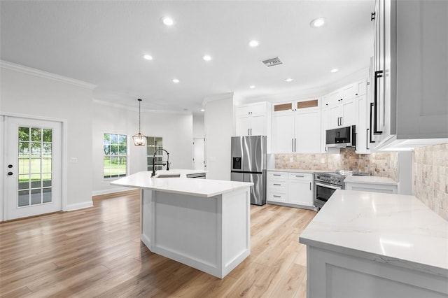 5820 E Johnson Ave, Haines City, FL 33844 - kitchen featuring appliances with stainless steel finishes, ornamental molding, a center island with sink, backsplash, and recessed lighting