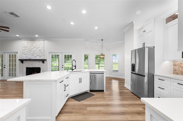 5820 E Johnson Ave, Haines City, FL 33844 - kitchen with appliances with stainless steel finishes, french doors, open floor plan, crown molding, and light wood finished floors