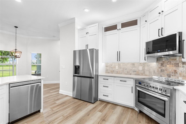 5820 E Johnson Ave, Haines City, FL 33844 - kitchen featuring stainless steel appliances, crown molding, light countertops, decorative backsplash, and a chandelier