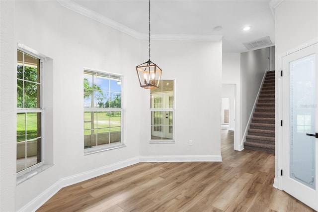 5820 E Johnson Ave, Haines City, FL 33844 - unfurnished dining area with stairway, a chandelier, light wood-type flooring, crown molding, and recessed lighting