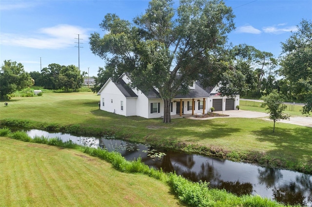 5820 E Johnson Ave, Haines City, FL 33844 - view of side of property with an attached garage, driveway, a yard, covered porch, and a water view