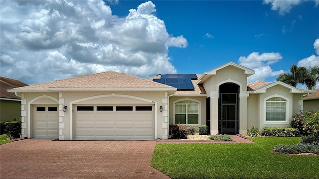 5340 Nicklaus Dr, Winter Haven, FL 33884 - view of front of house featuring stucco siding, decorative driveway, an attached garage, a front lawn, and solar panels