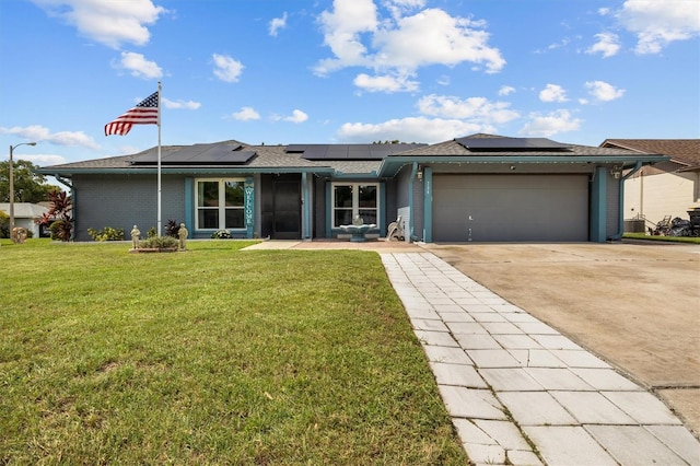 704 Butternut Pl, Lakeland, FL 33813 - view of front facade featuring a garage, a front lawn, driveway, and solar panels