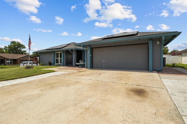 704 Butternut Pl, Lakeland, FL 33813 - ranch-style home with solar panels, concrete driveway, a front yard, and an attached garage