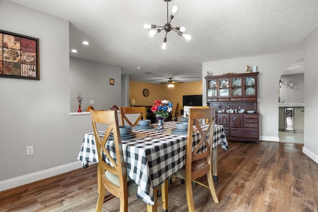 704 Butternut Pl, Lakeland, FL 33813 - dining room featuring arched walkways, wood finished floors, a textured ceiling, a chandelier, and beverage cooler