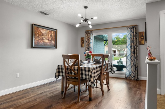 704 Butternut Pl, Lakeland, FL 33813 - dining room featuring a chandelier, a textured ceiling, and wood finished floors