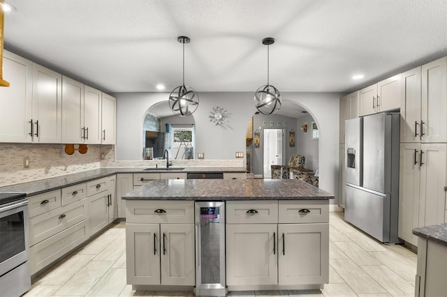704 Butternut Pl, Lakeland, FL 33813 - kitchen featuring appliances with stainless steel finishes, arched walkways, beverage cooler, a kitchen island, and recessed lighting