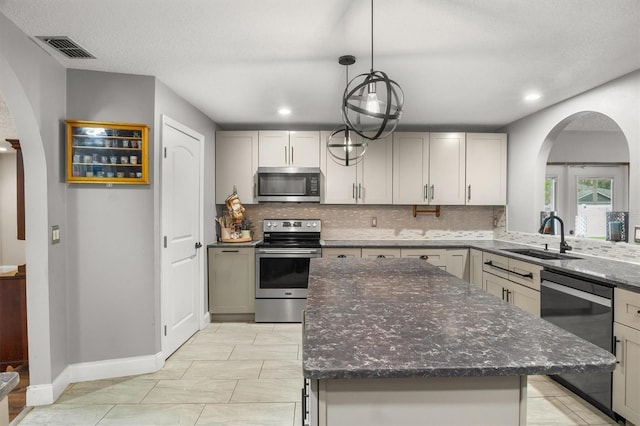 704 Butternut Pl, Lakeland, FL 33813 - kitchen featuring stainless steel appliances, arched walkways, backsplash, dark stone counters, and recessed lighting