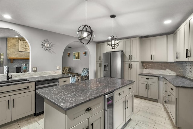 704 Butternut Pl, Lakeland, FL 33813 - kitchen featuring stainless steel appliances, arched walkways, wine cooler, backsplash, and dark stone counters
