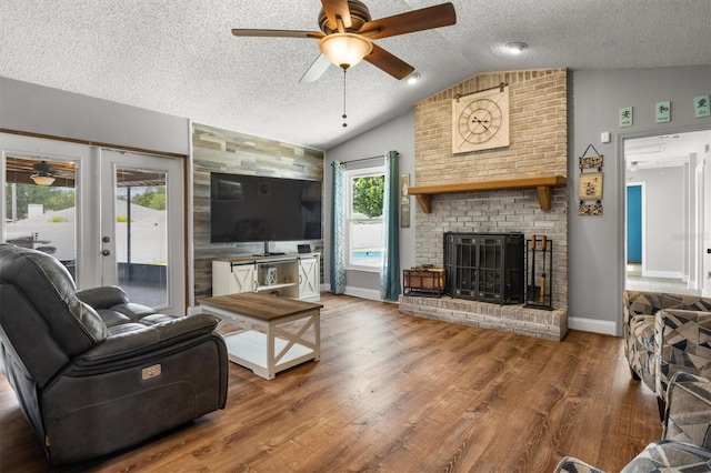 704 Butternut Pl, Lakeland, FL 33813 - living area with ceiling fan, a textured ceiling, lofted ceiling, wood finished floors, and a brick fireplace