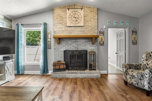 704 Butternut Pl, Lakeland, FL 33813 - living room with vaulted ceiling, wood finished floors, a brick fireplace, and a textured ceiling