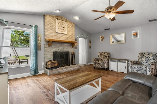 704 Butternut Pl, Lakeland, FL 33813 - living area with lofted ceiling, ceiling fan, wood finished floors, a fireplace, and a textured ceiling