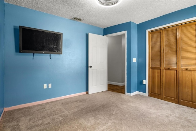 704 Butternut Pl, Lakeland, FL 33813 - unfurnished bedroom featuring carpet flooring, a closet, and a textured ceiling