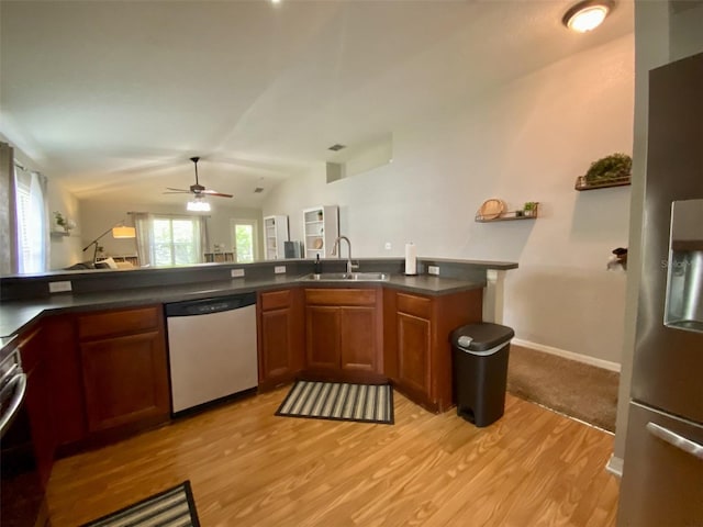 1790 Turtle Rock Dr, Lakeland, FL 33803 - kitchen with stainless steel appliances, light wood-style floors, dark countertops, brown cabinets, and vaulted ceiling