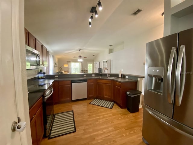 1790 Turtle Rock Dr, Lakeland, FL 33803 - kitchen with stainless steel appliances, dark countertops, ceiling fan, lofted ceiling, and light wood-type flooring