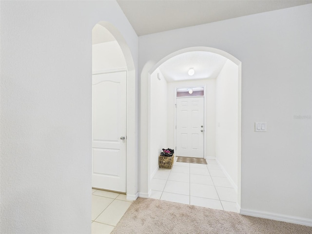 5751 Lakeside Landings Blvd, Winter Haven, FL 33881 - hall with light tile patterned flooring, arched walkways, and light carpet