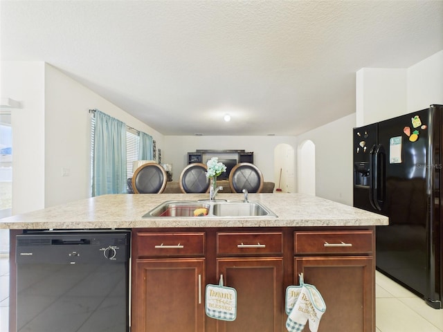 5751 Lakeside Landings Blvd, Winter Haven, FL 33881 - kitchen featuring black appliances, light countertops, open floor plan, reddish brown cabinets, and light tile patterned floors
