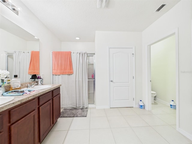 5751 Lakeside Landings Blvd, Winter Haven, FL 33881 - full bath with double vanity, a shower with curtain, a textured ceiling, and tile patterned flooring