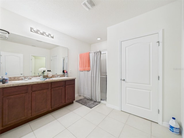 5751 Lakeside Landings Blvd, Winter Haven, FL 33881 - bathroom featuring a stall shower, double vanity, tile patterned floors, and a textured ceiling