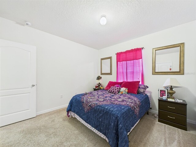 5751 Lakeside Landings Blvd, Winter Haven, FL 33881 - carpeted bedroom featuring baseboards and a textured ceiling