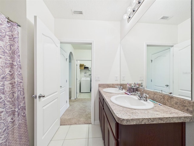 5751 Lakeside Landings Blvd, Winter Haven, FL 33881 - full bath featuring double vanity, tile patterned flooring, and washer / clothes dryer