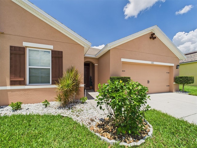 5751 Lakeside Landings Blvd, Winter Haven, FL 33881 - view of front of home featuring a garage, stucco siding, and driveway