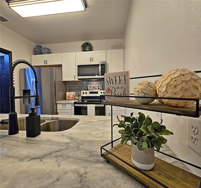 816 Pinewood Ct Unit 3126, Haines City, FL 33844 - kitchen with stainless steel appliances, white cabinetry, and backsplash