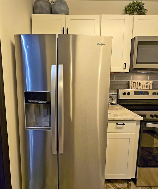 816 Pinewood Ct Unit 3126, Haines City, FL 33844 - kitchen with appliances with stainless steel finishes, white cabinetry, light stone countertops, and tasteful backsplash