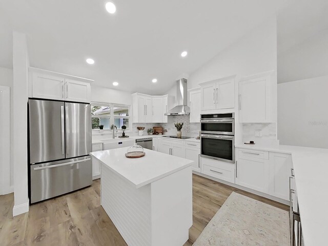 106 Corbett Rd, Lithia, FL 33547 - kitchen with stainless steel appliances, wall chimney exhaust hood, decorative backsplash, white cabinets, and light wood-style floors