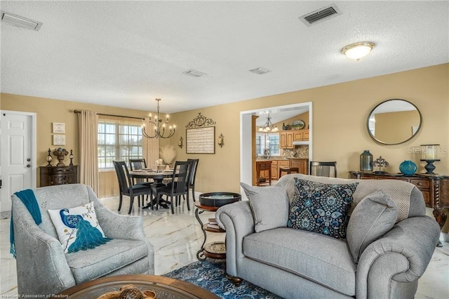 479 State Road 64 E, Zolfo Springs, FL 33890 - living room with a chandelier, light marble finish floors, and a textured ceiling