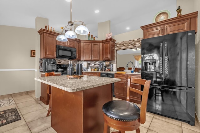 1366 Merrimack Pl, Davenport, FL 33837 - kitchen featuring black appliances, a center island, decorative backsplash, light tile patterned floors, and light countertops