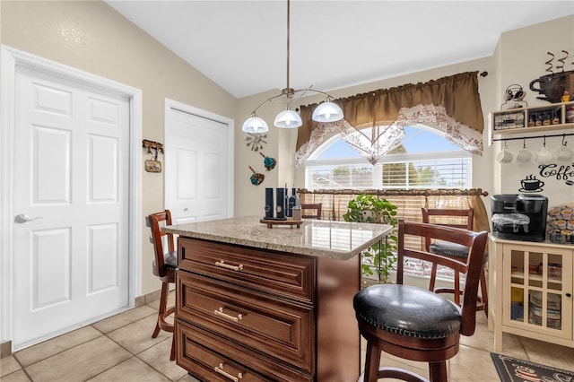 1366 Merrimack Pl, Davenport, FL 33837 - kitchen with light tile patterned floors, lofted ceiling, light stone countertops, pendant lighting, and a kitchen island