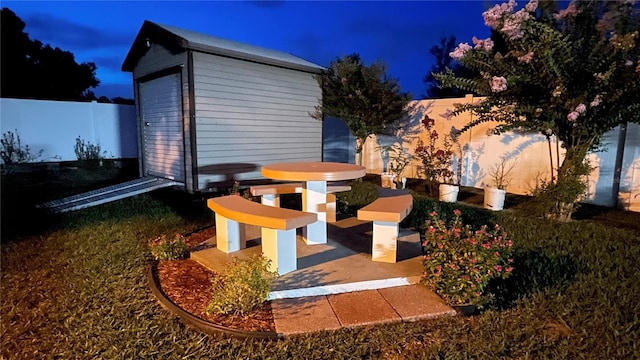 1366 Merrimack Pl, Davenport, FL 33837 - patio at night with a fenced backyard and a storage unit
