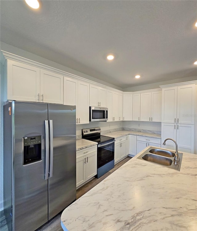 3040 W Joliet Rd, Avon Park, FL 33825 - kitchen featuring appliances with stainless steel finishes, white cabinets, light stone counters, recessed lighting, and dark wood-style flooring