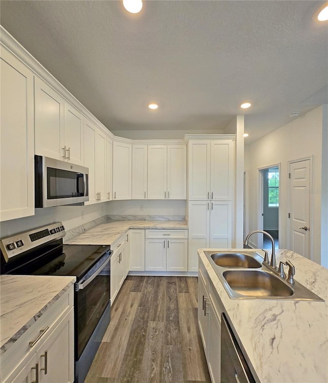 3040 W Joliet Rd, Avon Park, FL 33825 - kitchen featuring stainless steel appliances, dark wood-style flooring, white cabinets, recessed lighting, and light stone counters