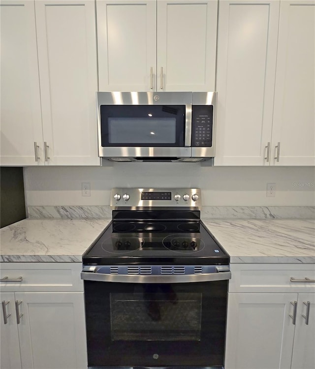 3040 W Joliet Rd, Avon Park, FL 33825 - kitchen with stainless steel appliances, white cabinetry, and light stone countertops