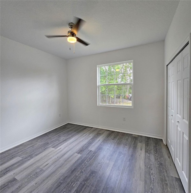3040 W Joliet Rd, Avon Park, FL 33825 - unfurnished bedroom with dark wood-style floors, a closet, ceiling fan, and a textured ceiling