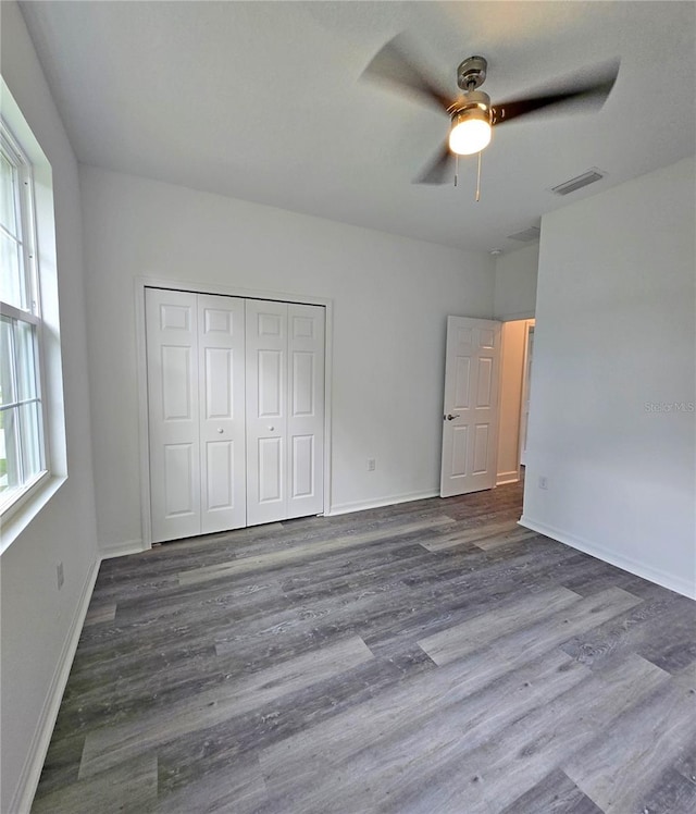 3040 W Joliet Rd, Avon Park, FL 33825 - unfurnished bedroom featuring multiple windows, wood finished floors, a closet, and ceiling fan