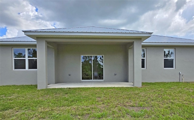 3040 W Joliet Rd, Avon Park, FL 33825 - rear view of house featuring stucco siding, a patio, a metal roof, and a yard