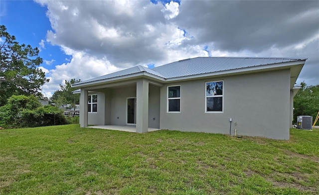 3040 W Joliet Rd, Avon Park, FL 33825 - rear view of house with stucco siding, a patio, a lawn, and a metal roof
