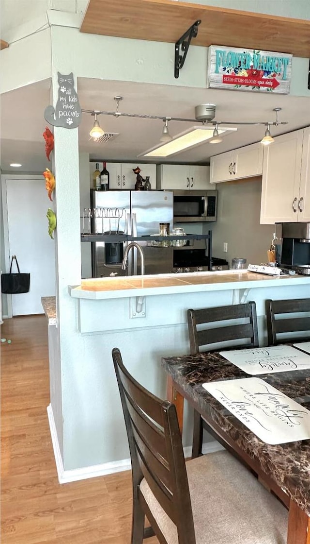 7906 Waterview Way Unit 7906, Winter Haven, FL 33884 - kitchen featuring stainless steel appliances, light wood-style flooring, and white cabinets