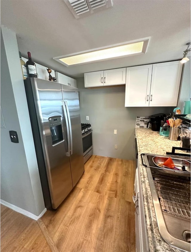 7906 Waterview Way Unit 7906, Winter Haven, FL 33884 - kitchen with stainless steel appliances, white cabinetry, and light wood finished floors