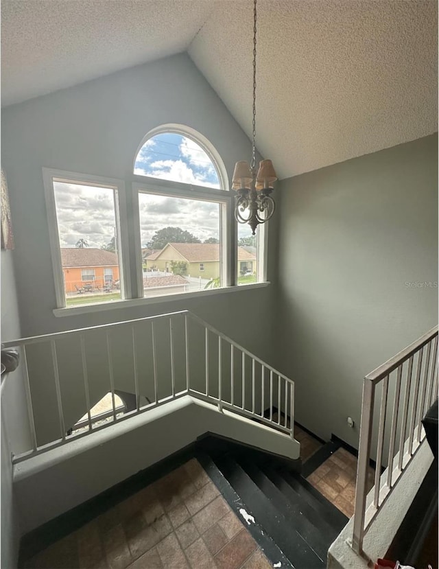 7906 Waterview Way Unit 7906, Winter Haven, FL 33884 - unfurnished dining area featuring a chandelier, vaulted ceiling, a textured ceiling, and stairs