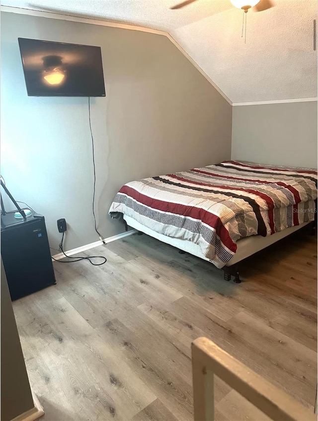 7906 Waterview Way Unit 7906, Winter Haven, FL 33884 - bedroom with wood finished floors, vaulted ceiling, a textured ceiling, ornamental molding, and a ceiling fan